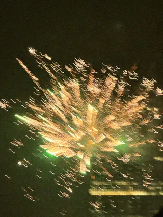 Motion blur photograph of golden fireworks bursting against a dark night sky